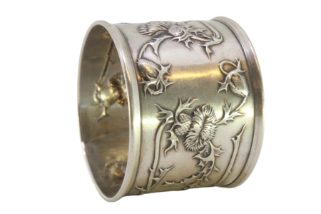 Argola de guardanapo em prata com motivos florais relevados envolvendo cartela para monograma.